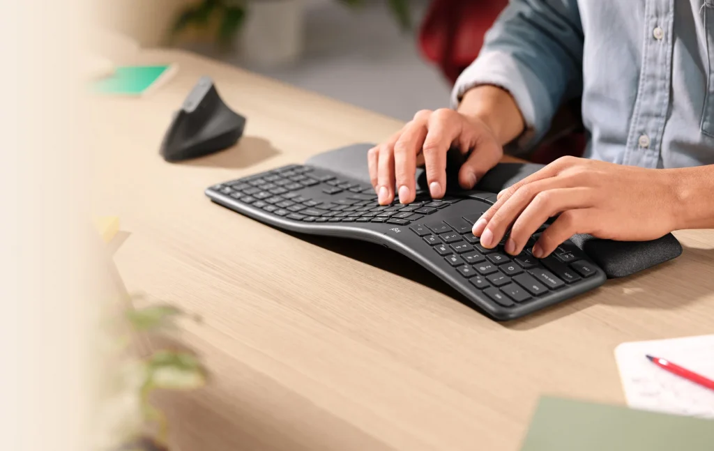 Mężczyzna piszący na klawiaturze ergonomicznej.